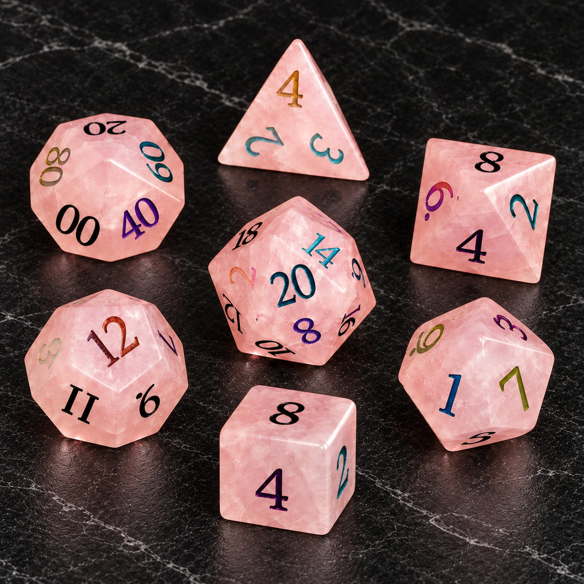 Prismrose Oracle - seven-piece dice set flat lay on black marble