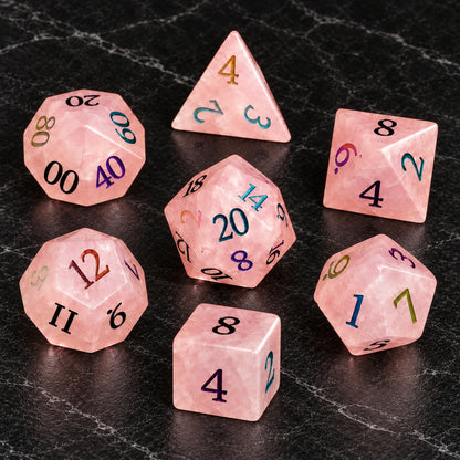 Prismrose Oracle - seven-piece dice set flat lay on black marble