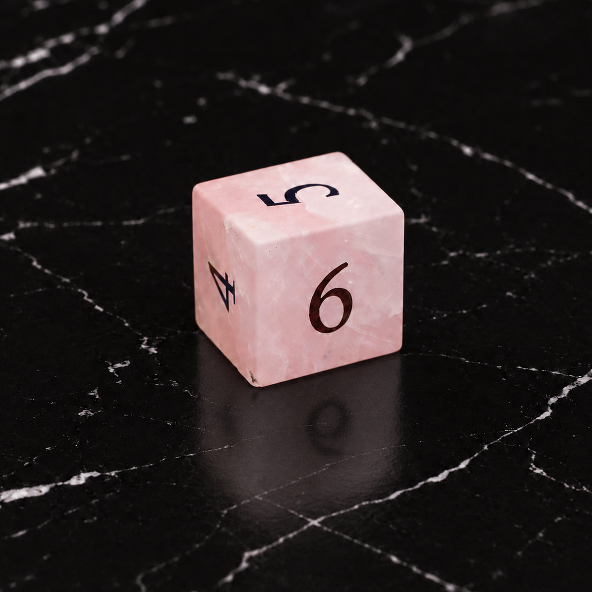 Prismrose Oracle - D6 gemstone die on black marble